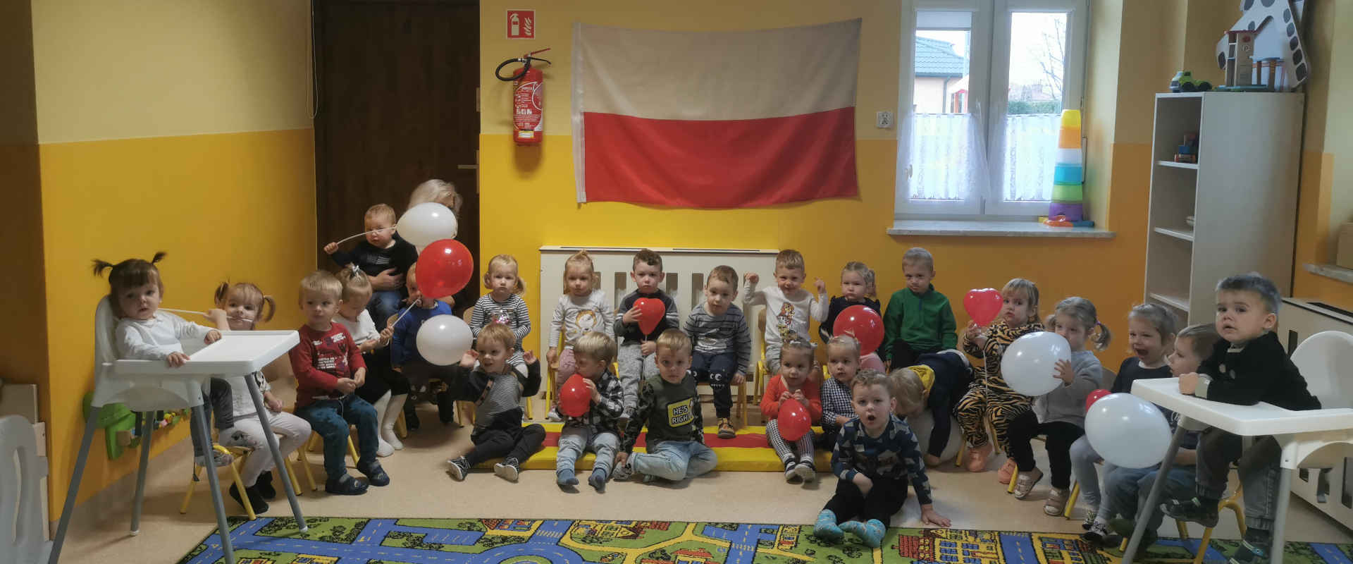 Dzieci wyklejają serce w kolorach biało-czerwonych
