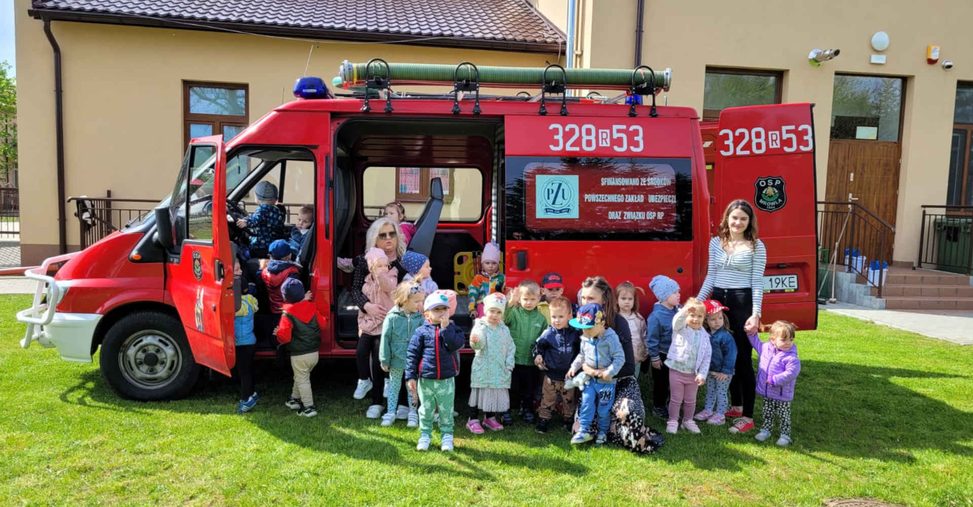 Czerwony wóz strażacki i wokół niego dzieci